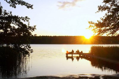 Paare auf dem Steg bei Sonnenuntergang